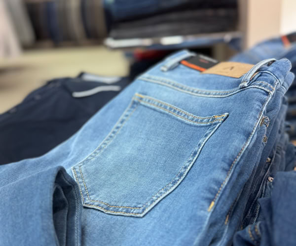 Ein Stapel blauer Jeanshosen auf einem Tisch in einem Geschäft.